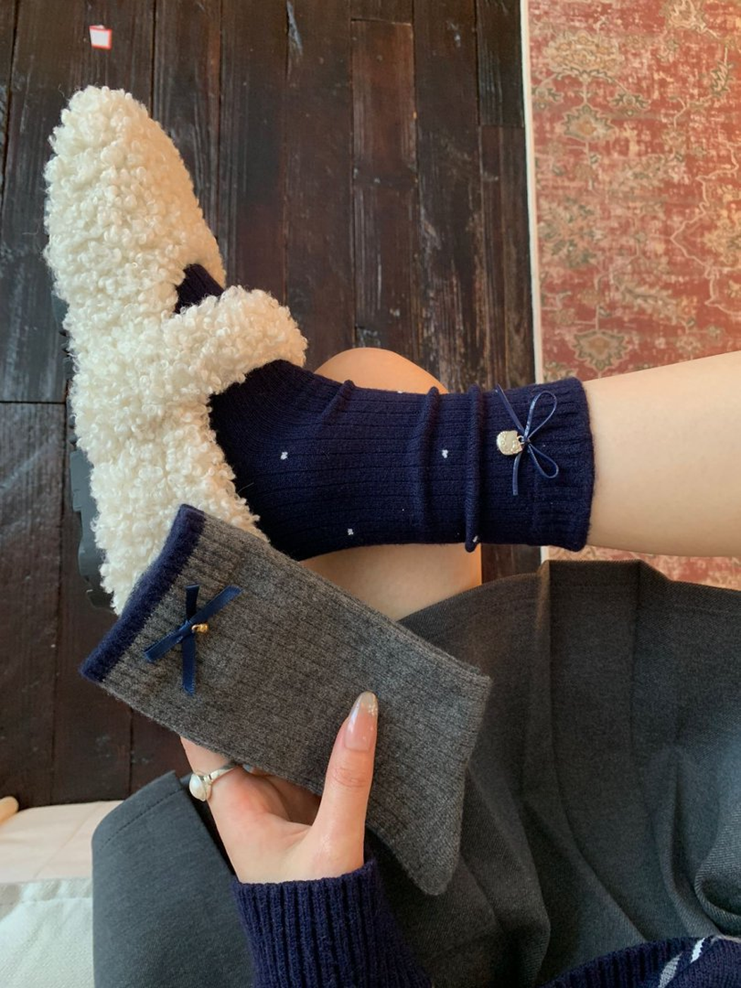 Navy Metal Charm sock worn with a dark gray bow sock held alongside