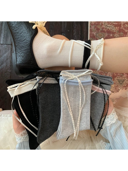 White crew sock with black cuff worn above folded ribbon-trim color options