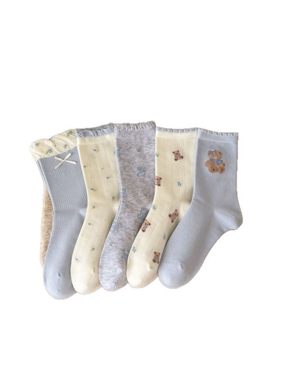 Five light blue, ivory, and heather gray crew sock styles on a white background