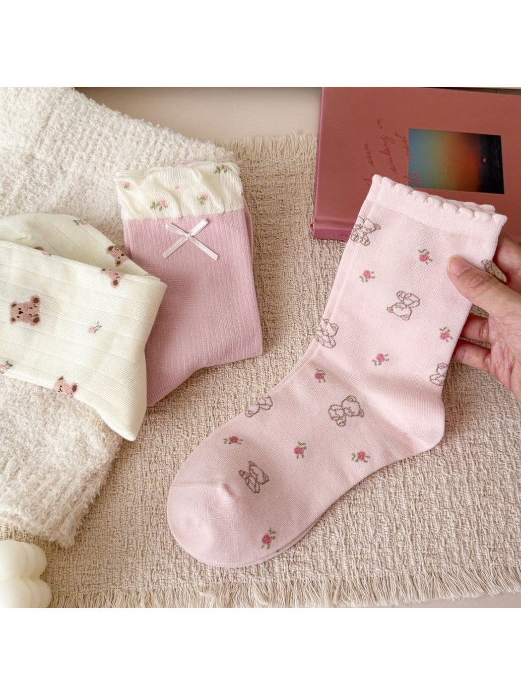 Close-up of light pink crew socks with outlined teddy bears and small flowers