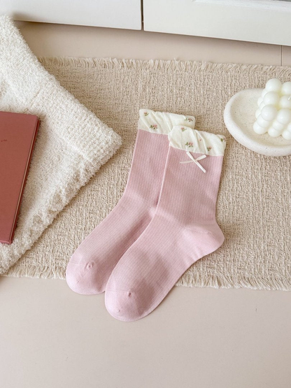 Dusty pink crew socks with floral contrast cuffs, a bow and fine ribbing