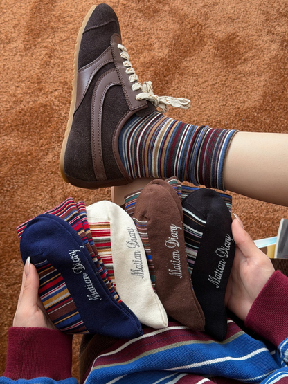 Multiple colors of striped crew socks styled with a sneaker