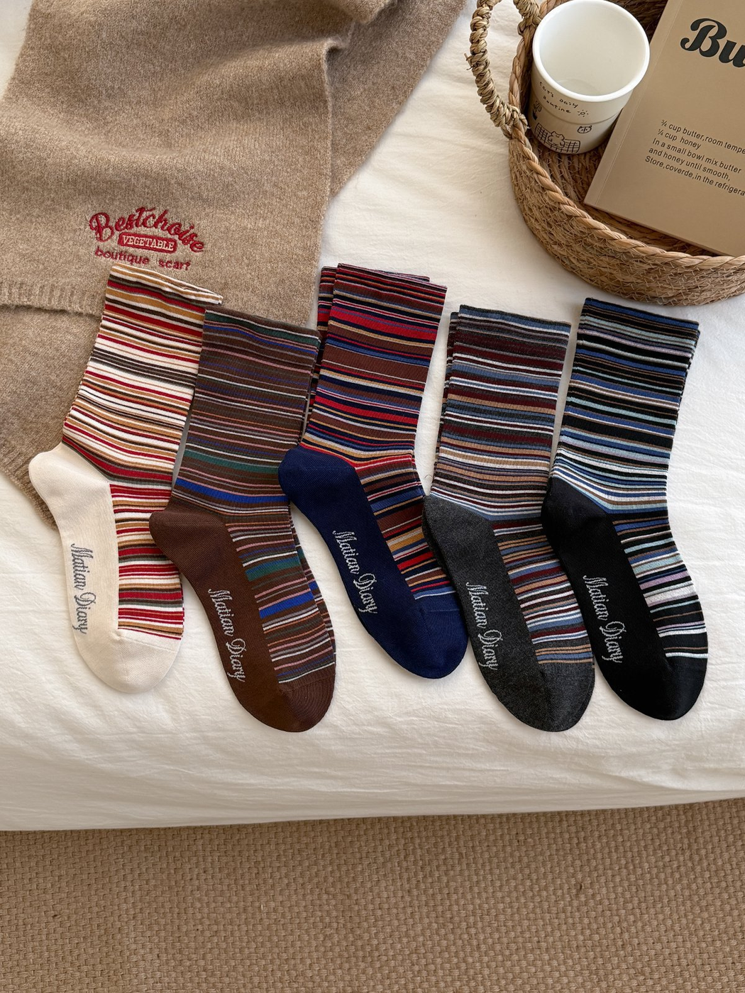 Five colors of multicolor striped crew socks arranged in a flat lay