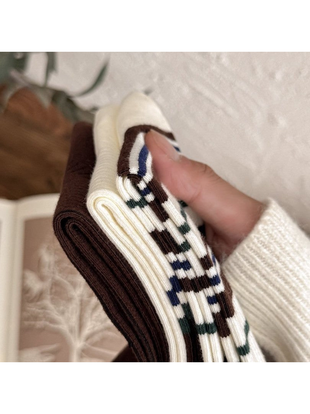 Close-up of folded ribbed socks in ivory and brown patterns