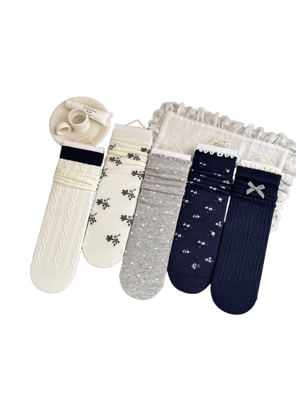 Five sock styles in ivory, heather gray and navy displayed together