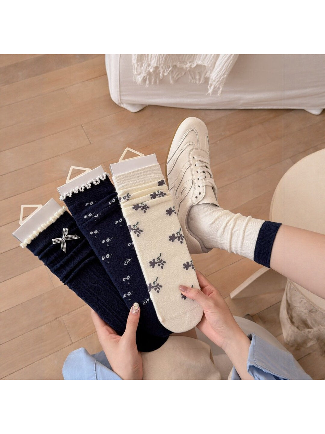 Navy and ivory patterned socks displayed beside an ivory cable-pattern pair worn with sneakers