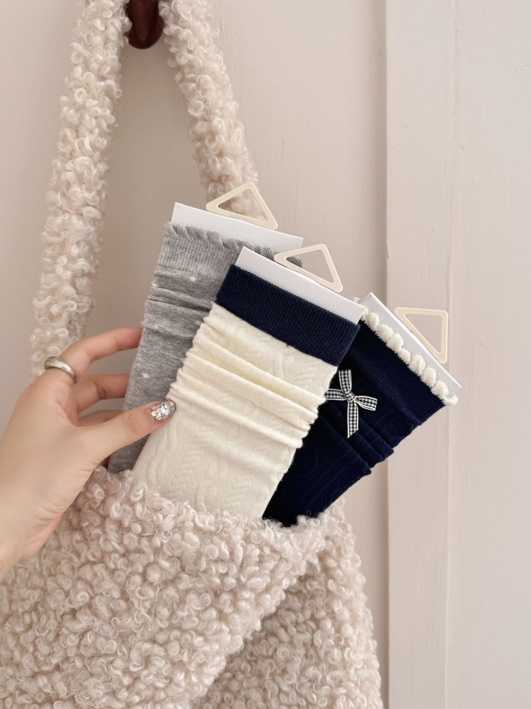 Gray, ivory and navy sock styles displayed in a textured tote bag