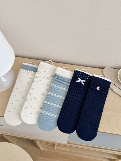 Five crew sock styles in ivory, light blue and navy displayed together