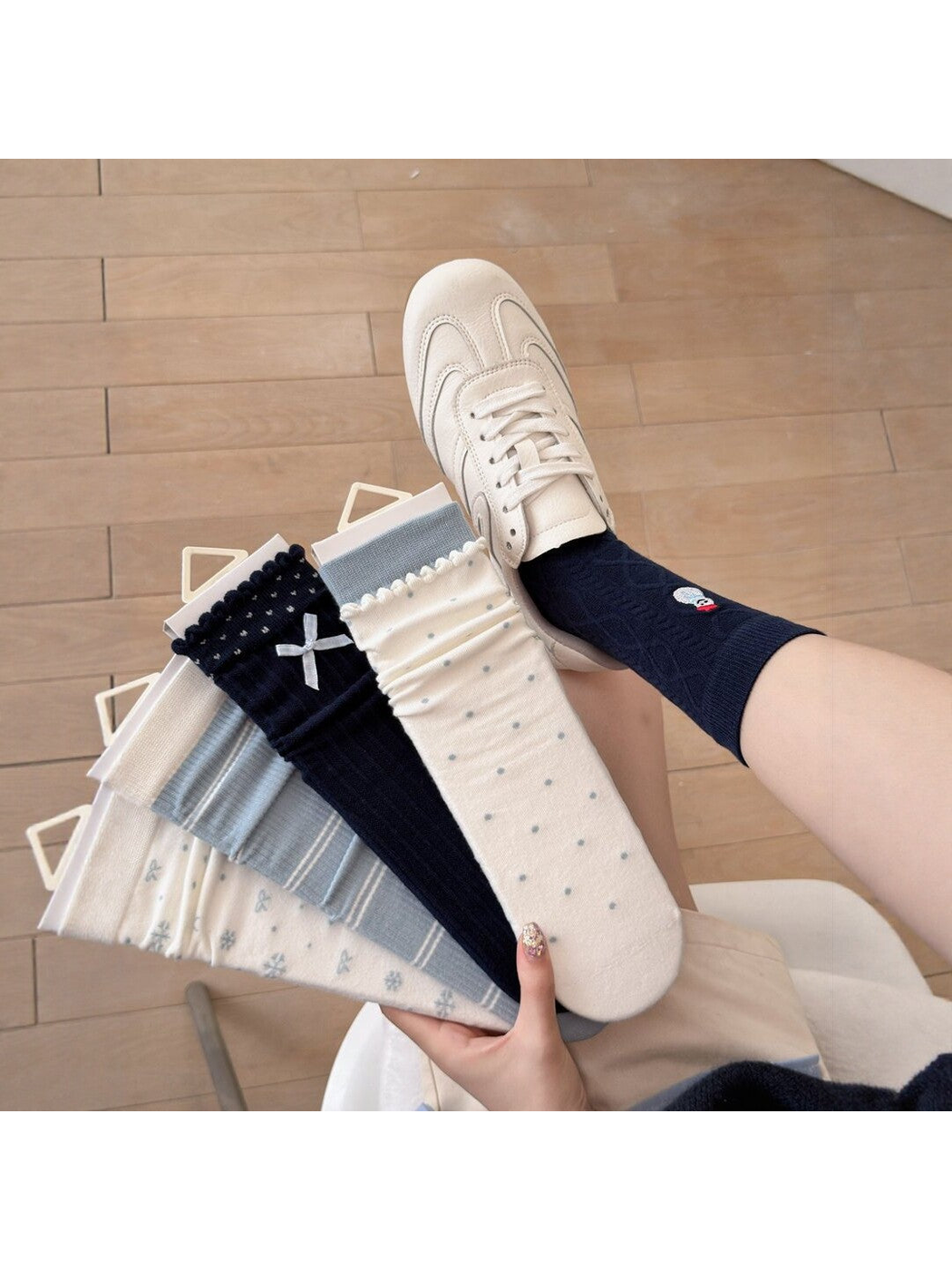 Five ivory, light blue and navy crew sock styles displayed with a navy snowman style worn