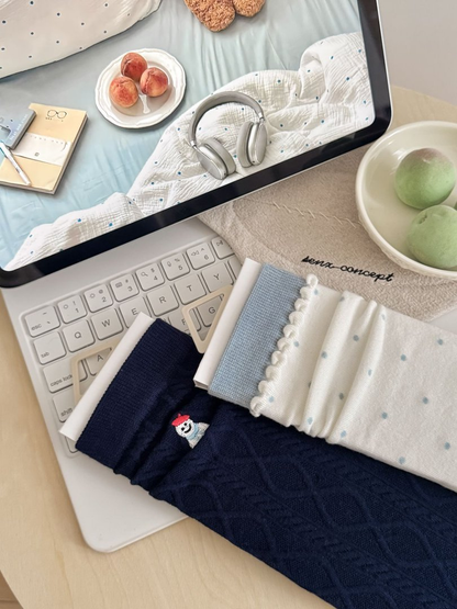 Close view of navy snowman cable-knit and ivory polka-dot sock details