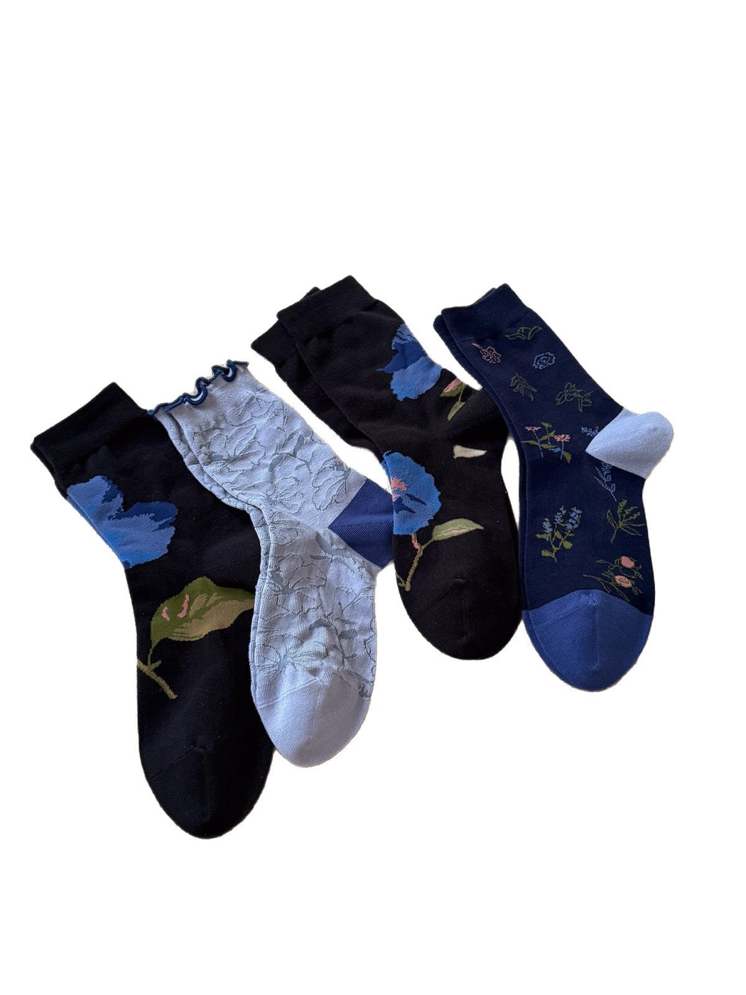 Four floral crew sock styles displayed together on a white background