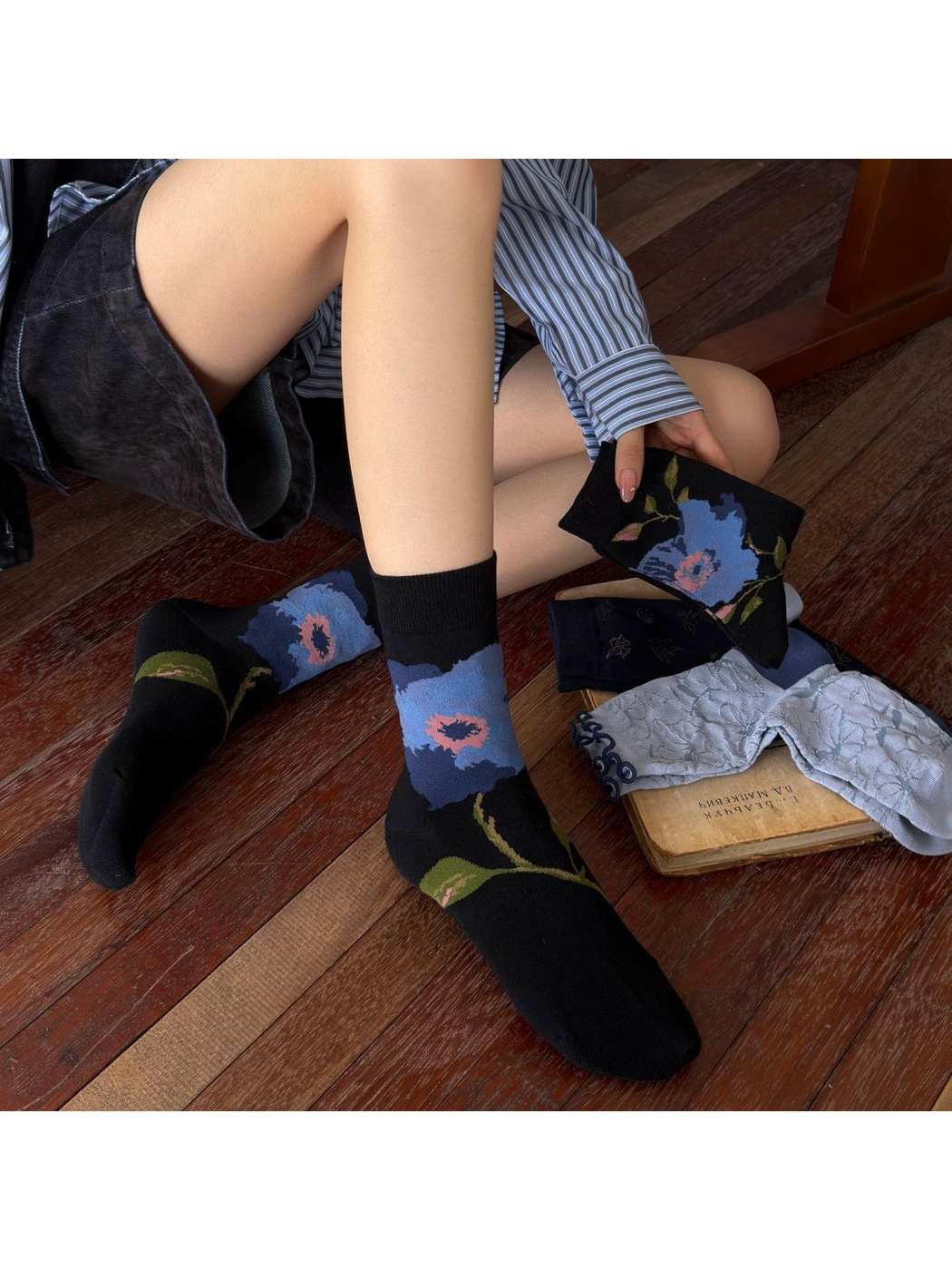 Black floral crew socks worn in a seated indoor setting