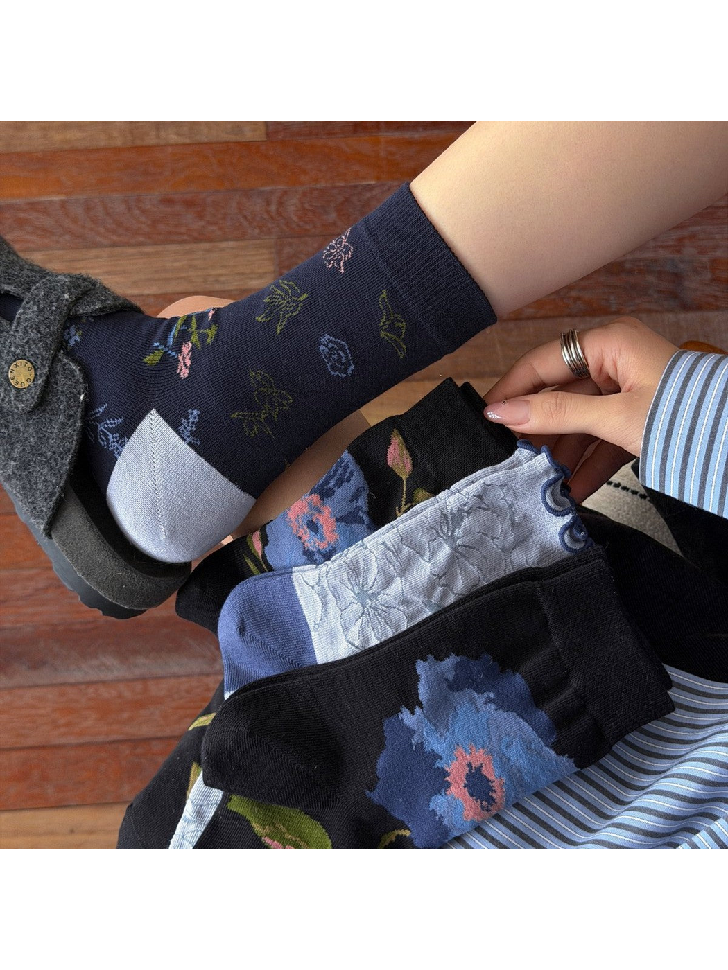 Close-up of contrasting toes, floral patterns and a ruffled cuff