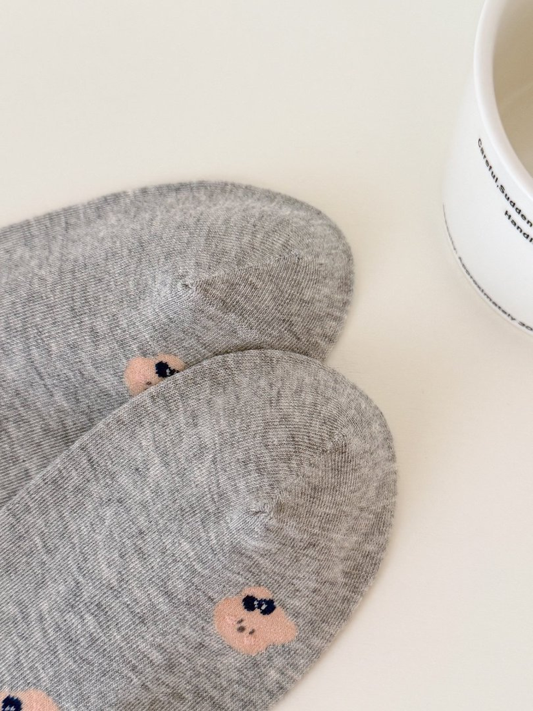 Close-up of Light Gray sock toes and the repeating bear-face motif
