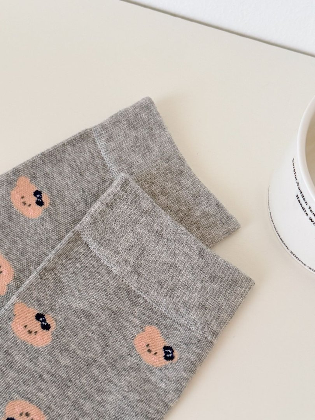 Close-up of ribbed Light Gray sock cuffs and bear-face motifs
