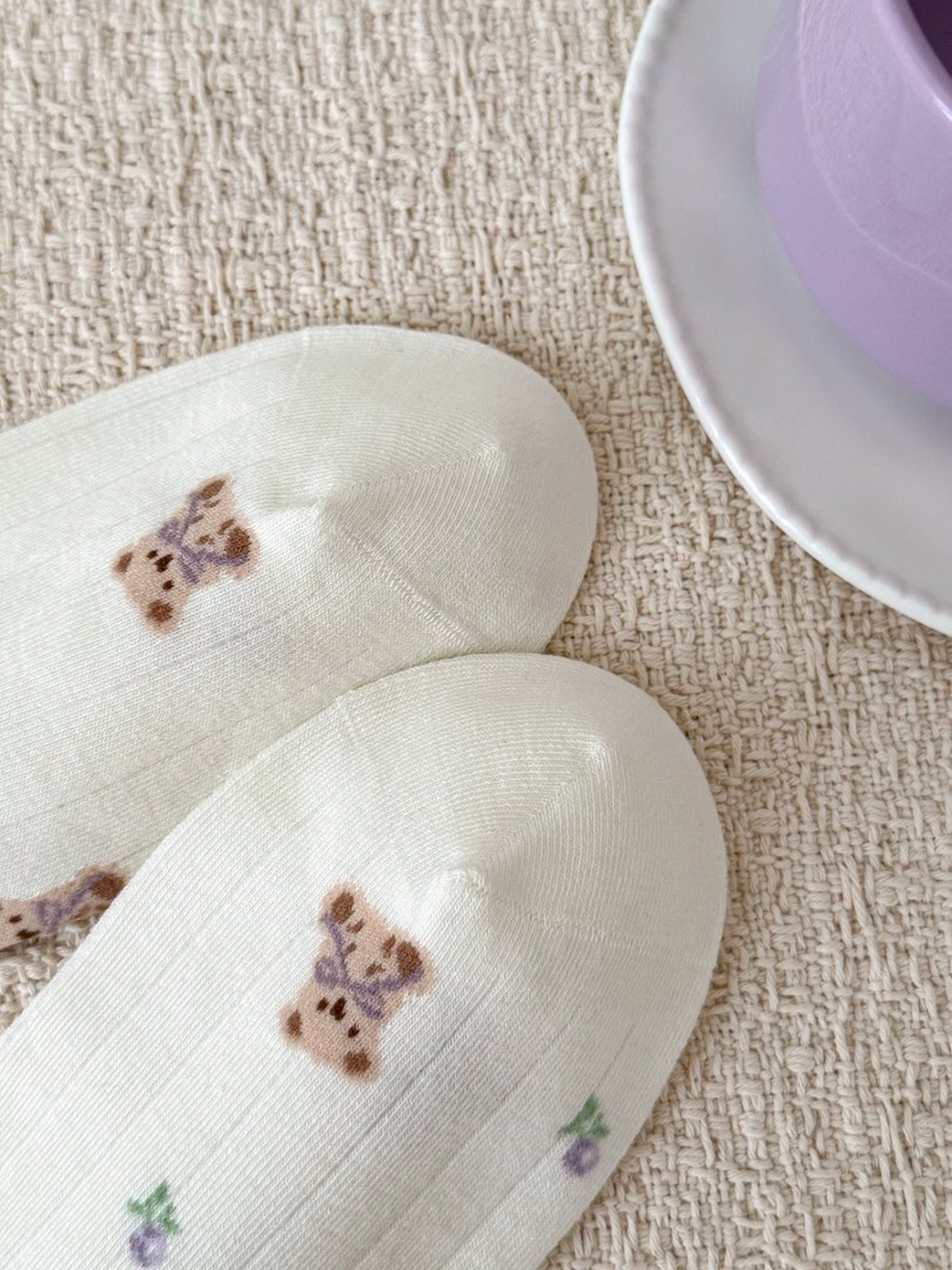 Close-up of teddy bear print and toe shaping on ivory socks