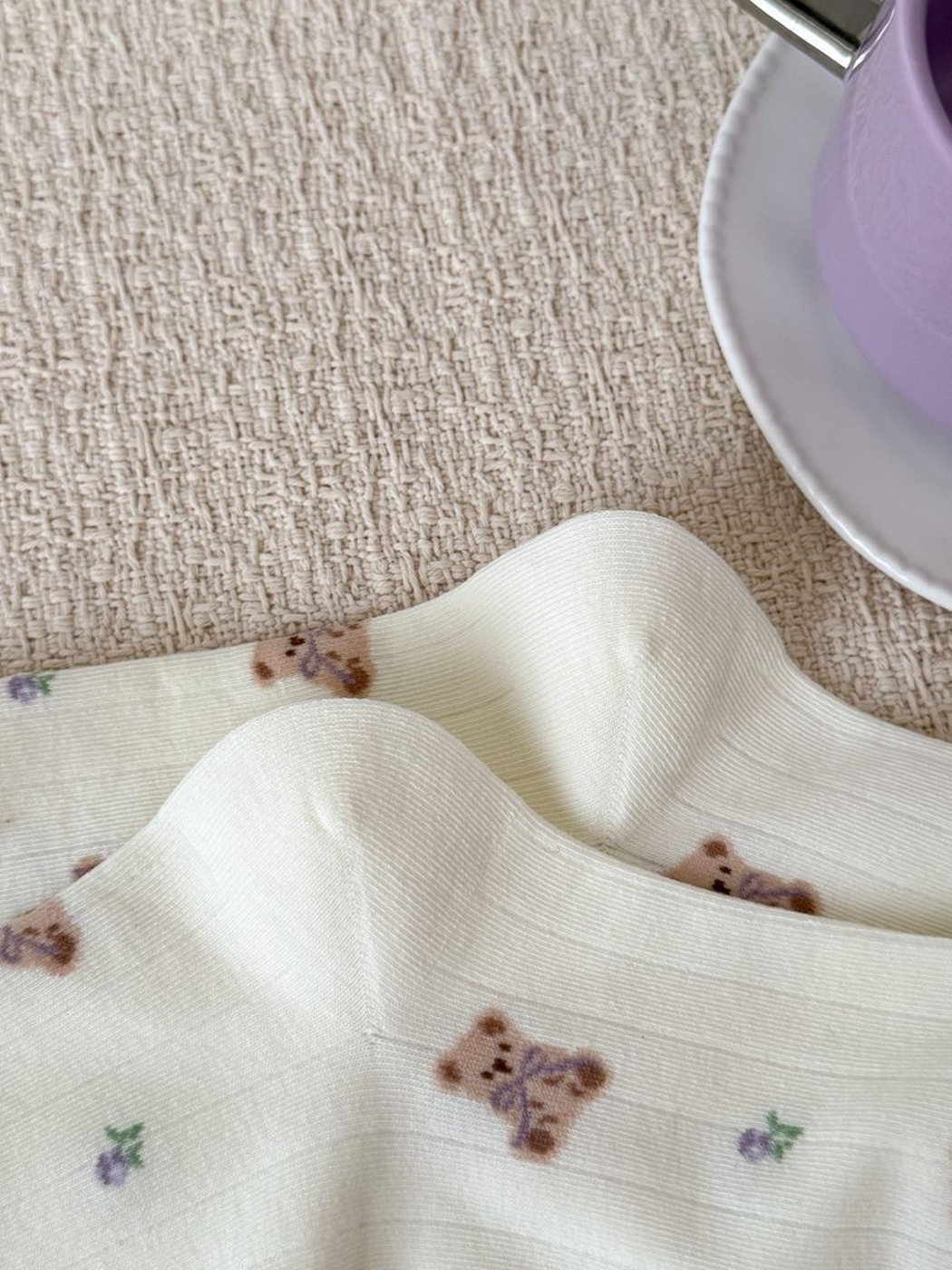 Close-up of teddy bear print and shaped heels on ivory socks