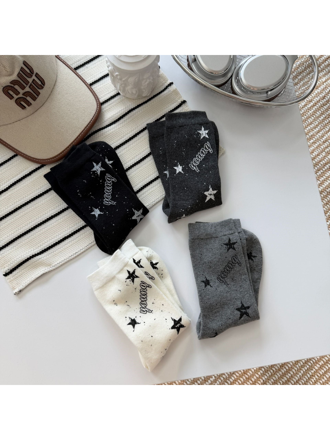 Black, ivory, dark gray and light gray star-print crew socks arranged in pairs