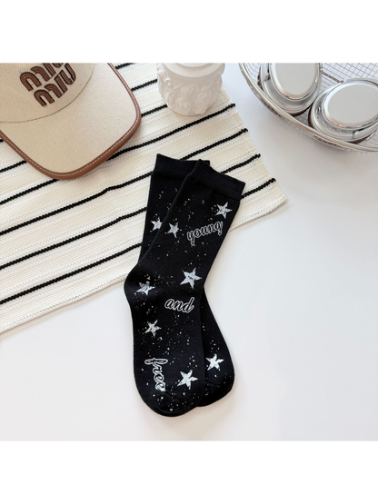 Black crew socks with white stars, speckles and script lettering