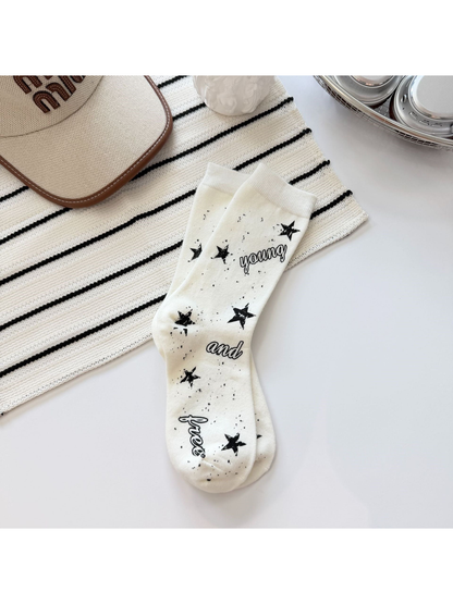 Ivory crew socks with black stars, speckles and script lettering