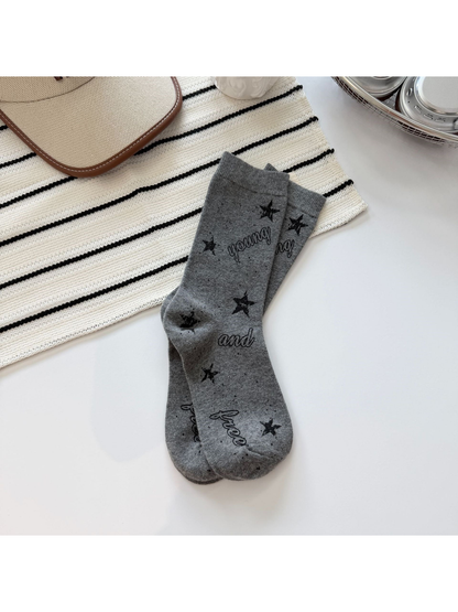 Light gray crew socks with black stars, speckles and script lettering