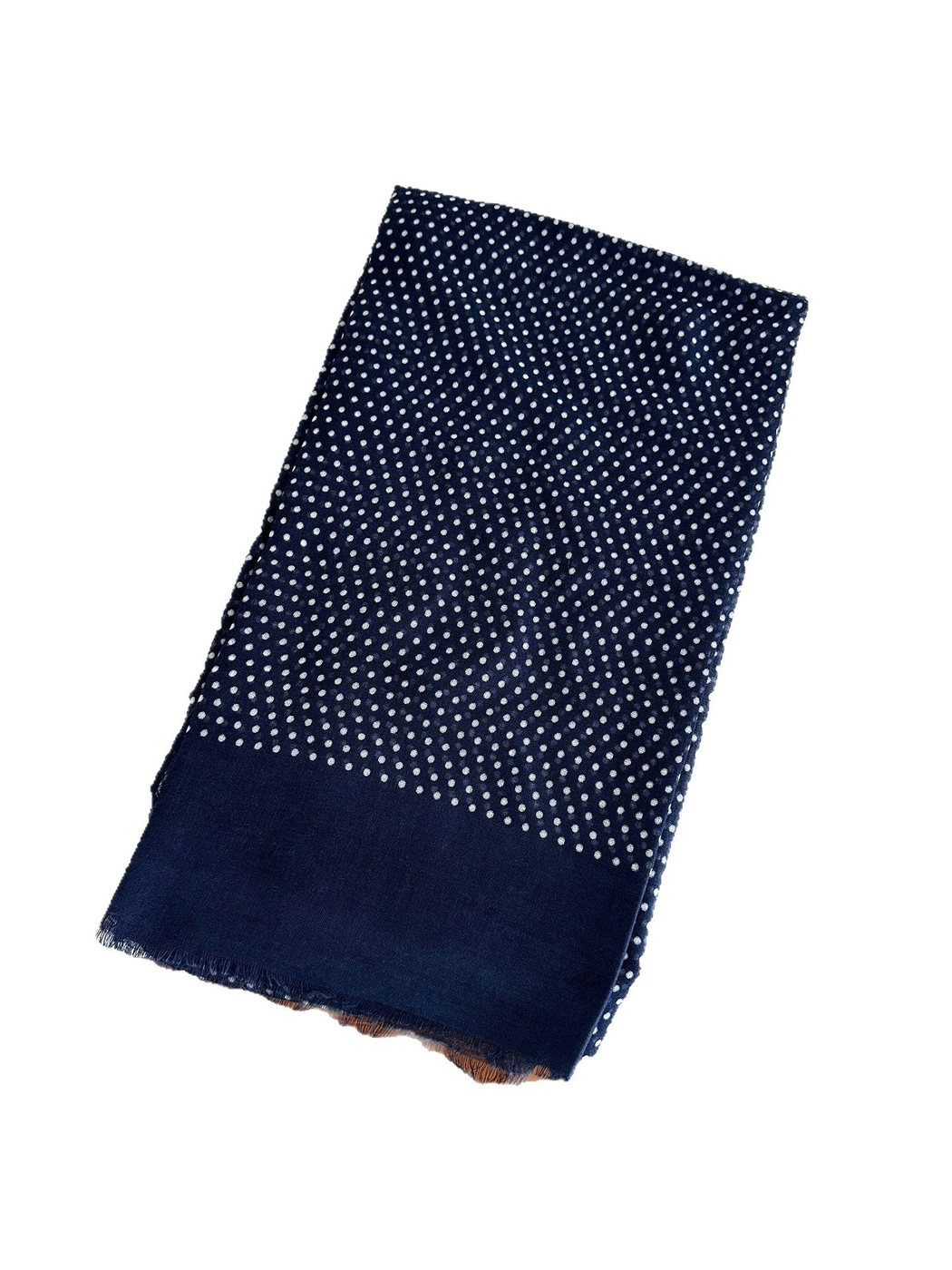 Folded navy polka dot scarf with a wide plain border and fringed end