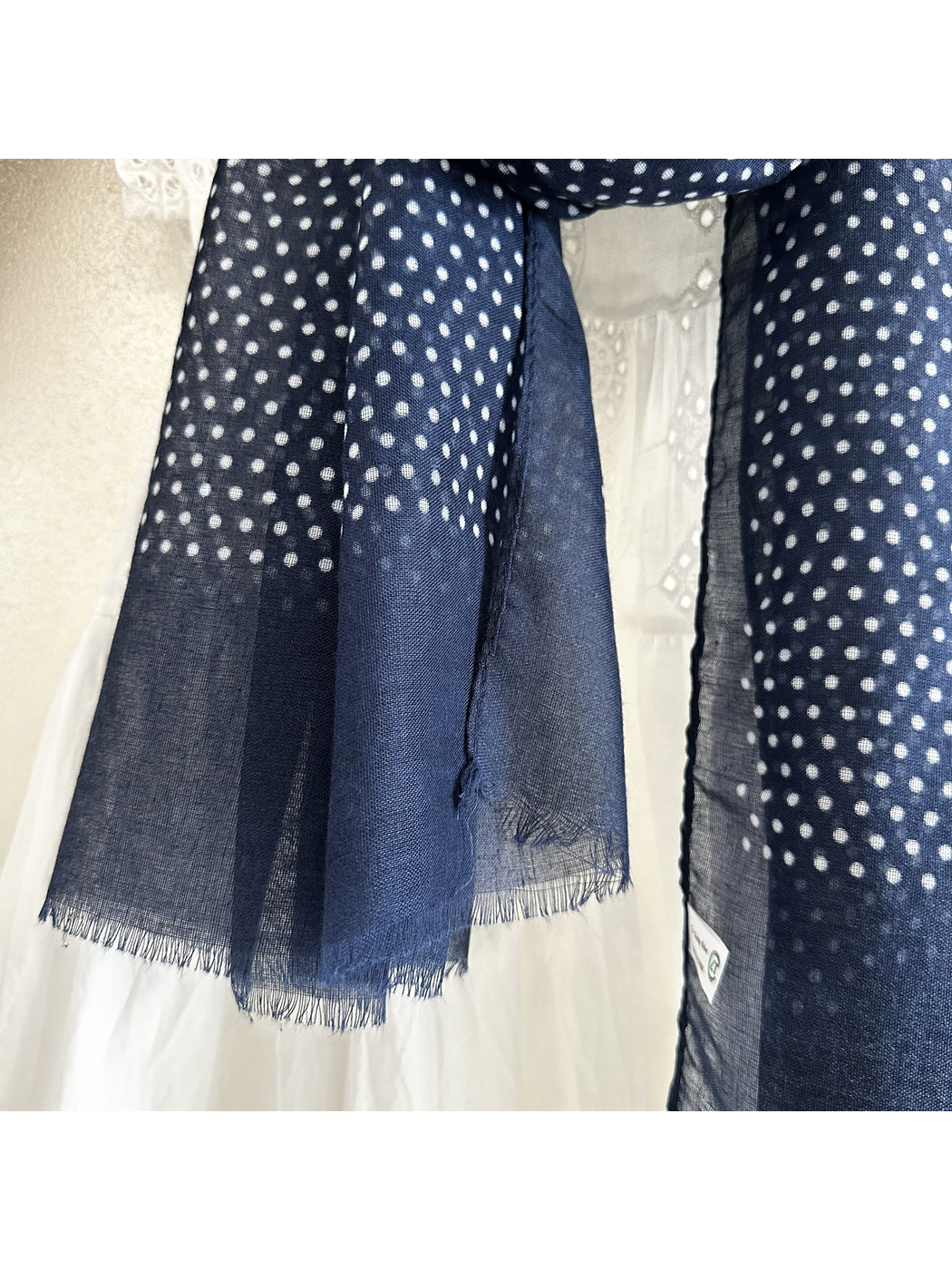 Close-up of the semi-sheer navy polka dot surface and short fringe