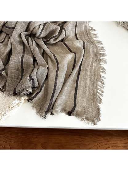 Close-up of the narrow stripes, crinkled texture and fringed scarf edge