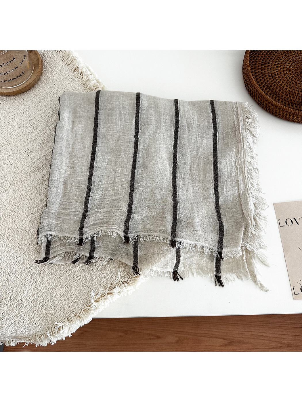 Khaki striped scarf folded to show its crinkled texture and fringed edges