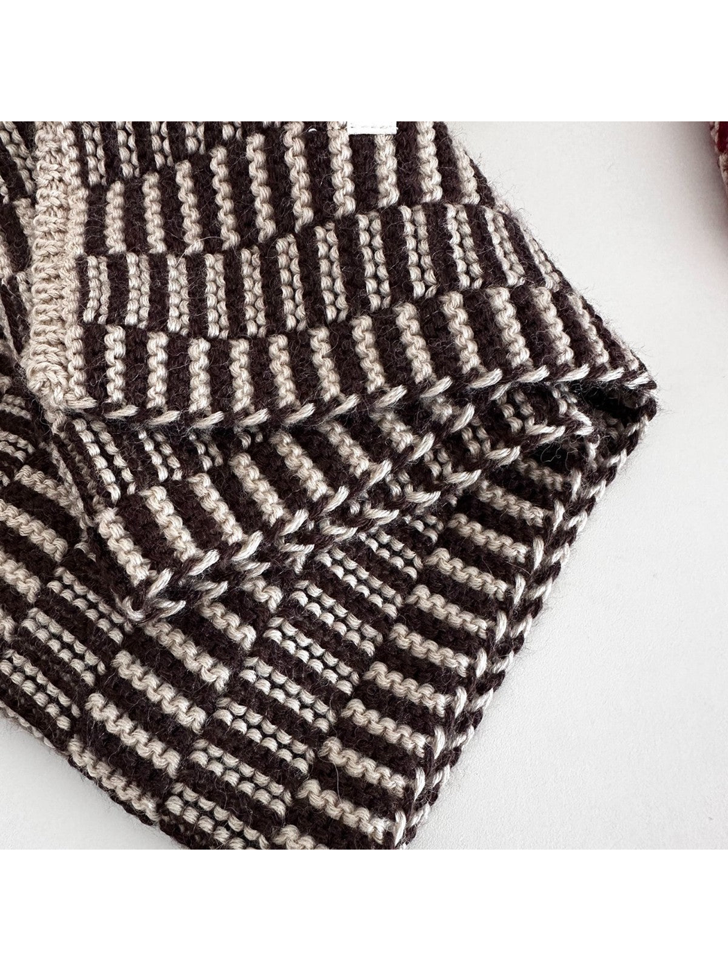 Close-up of the striped knit texture and contrasting finished edge