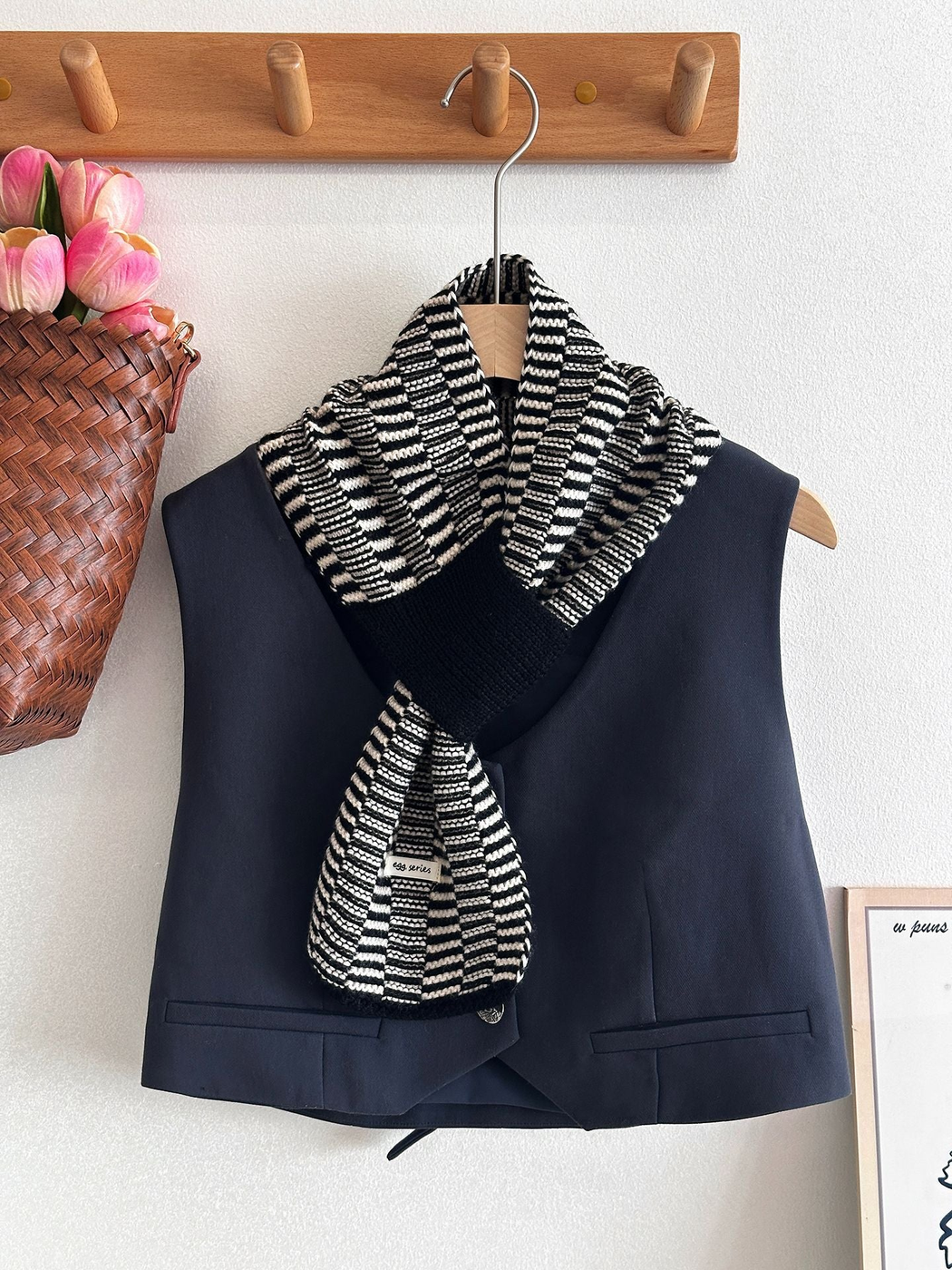 Black and white striped scarf draped over a navy vest