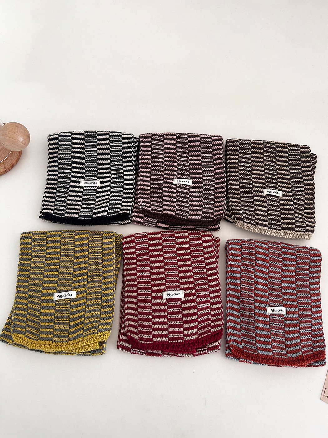 Six striped scarf color combinations displayed folded in two rows