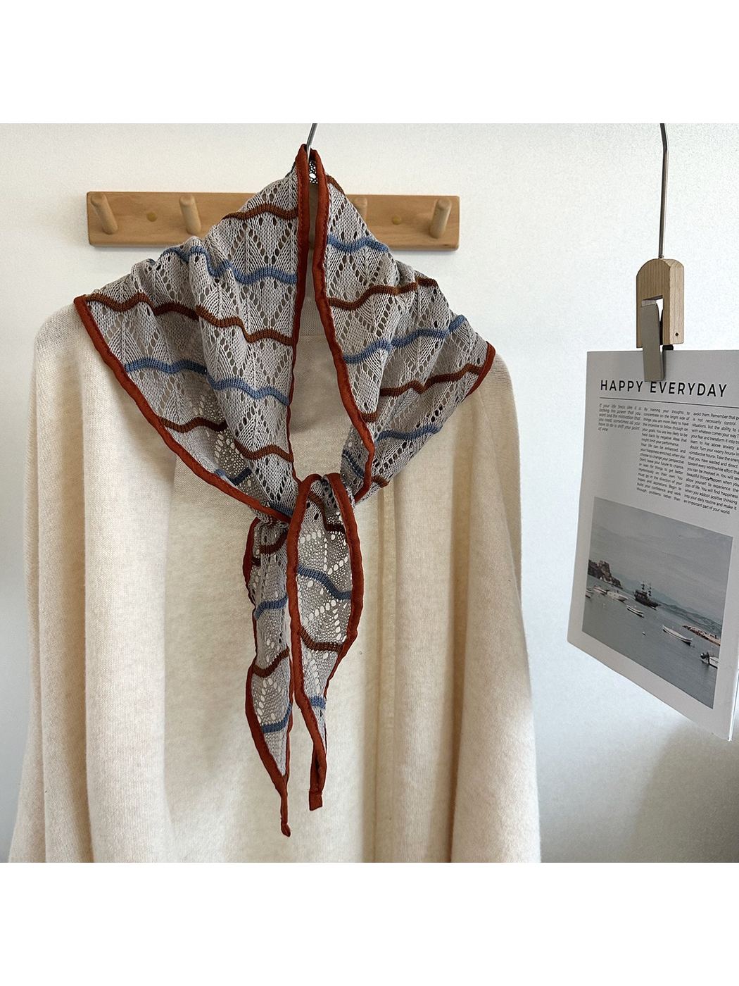 Light Gray openwork triangle scarf tied over an ivory sweater