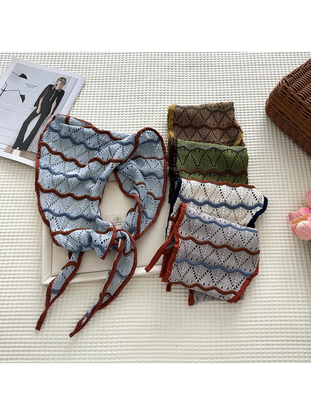 Openwork triangle scarves in several colors arranged with one Light Blue scarf tied in front