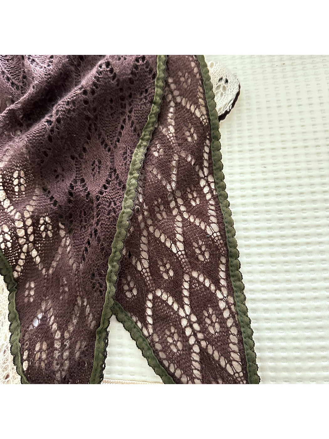 Close-up of the Dark Brown openwork pattern and olive scalloped trim