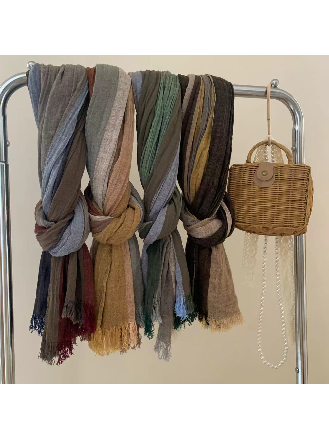 Multiple multicolor scarves draped and knotted on a garment rack