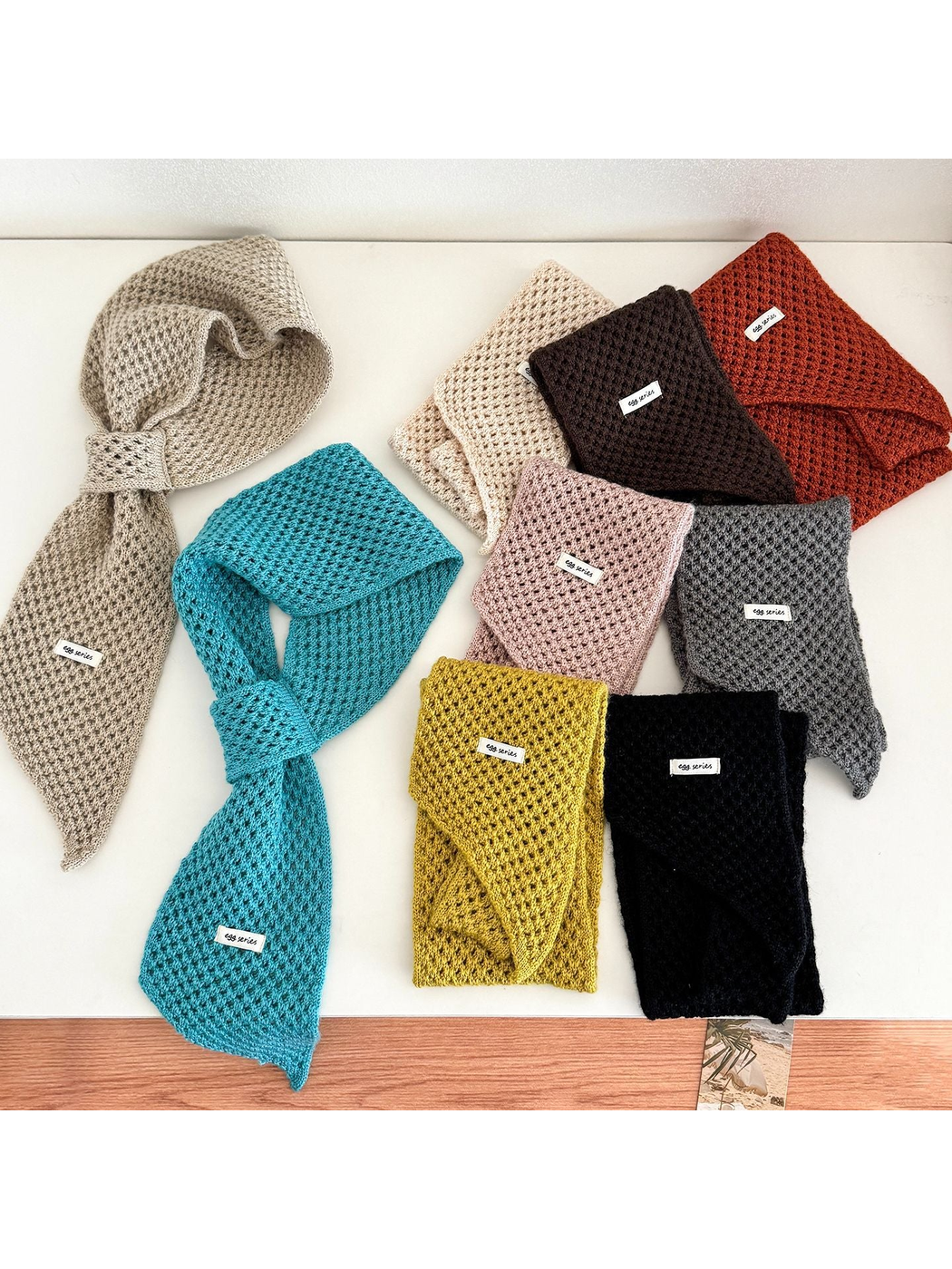 Assorted openwork pull-through scarves arranged together in multiple colors