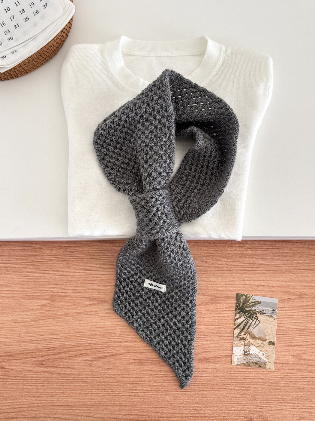 Dark Gray openwork pull-through scarf displayed with a folded white top