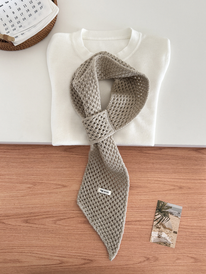 Cream openwork pull-through scarf displayed with a folded white top