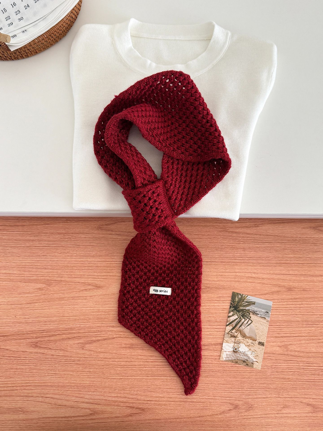 Burgundy openwork pull-through scarf displayed with a folded white top