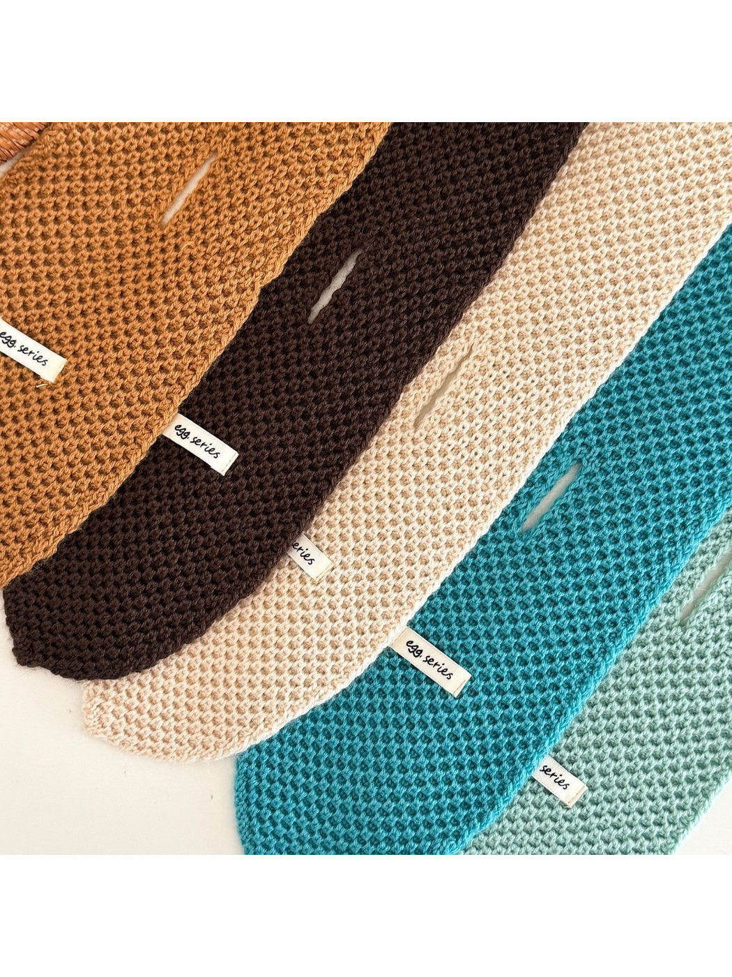 Close-up of textured knit scarves with pull-through slits