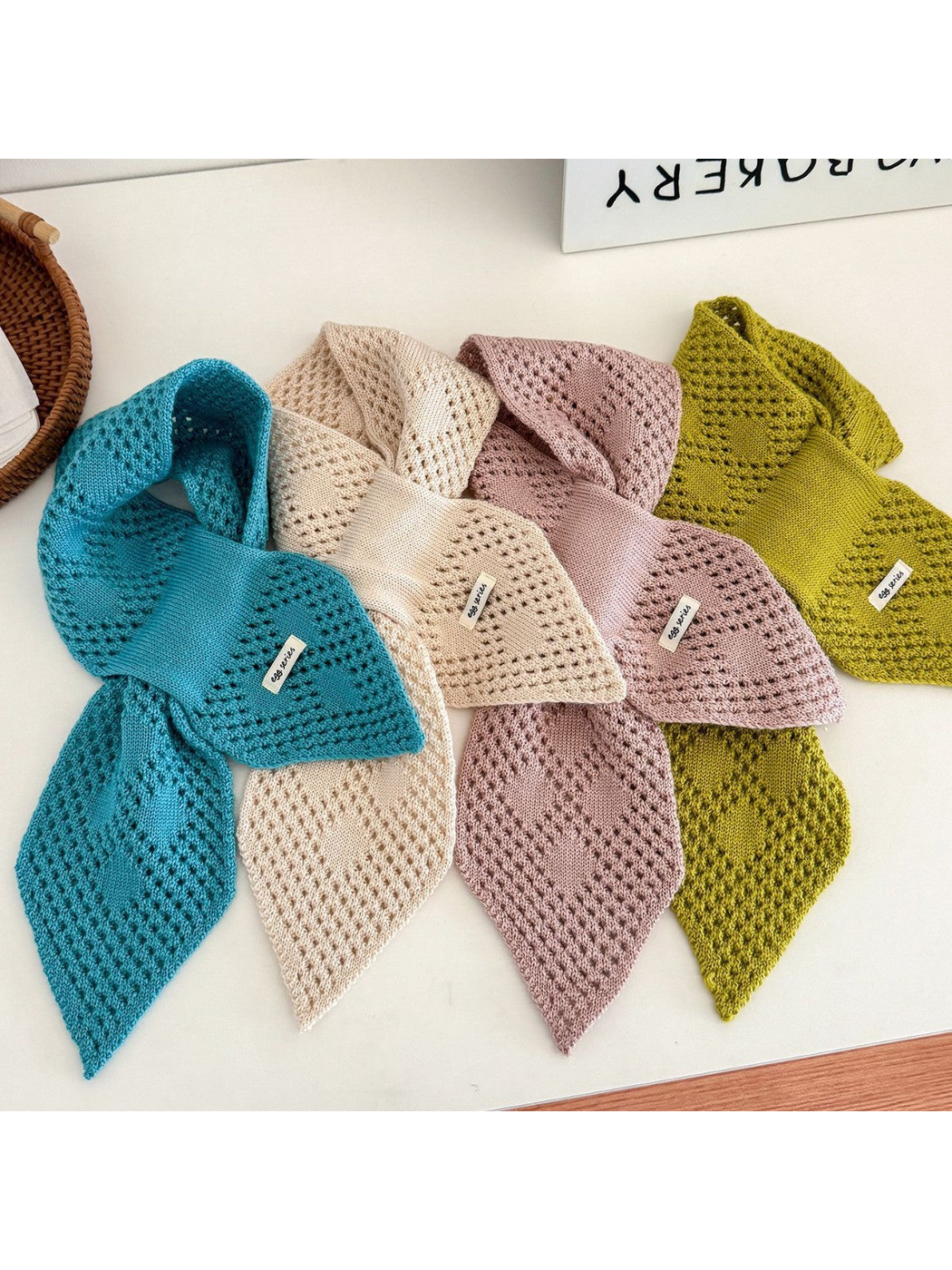 Lake blue, off white, nude pink and yellow green pull-through scarves displayed together