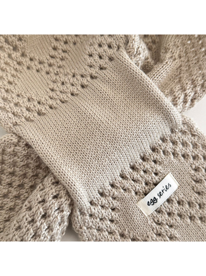 Close-up of the knit texture, eyelet bands and tapered scarf end
