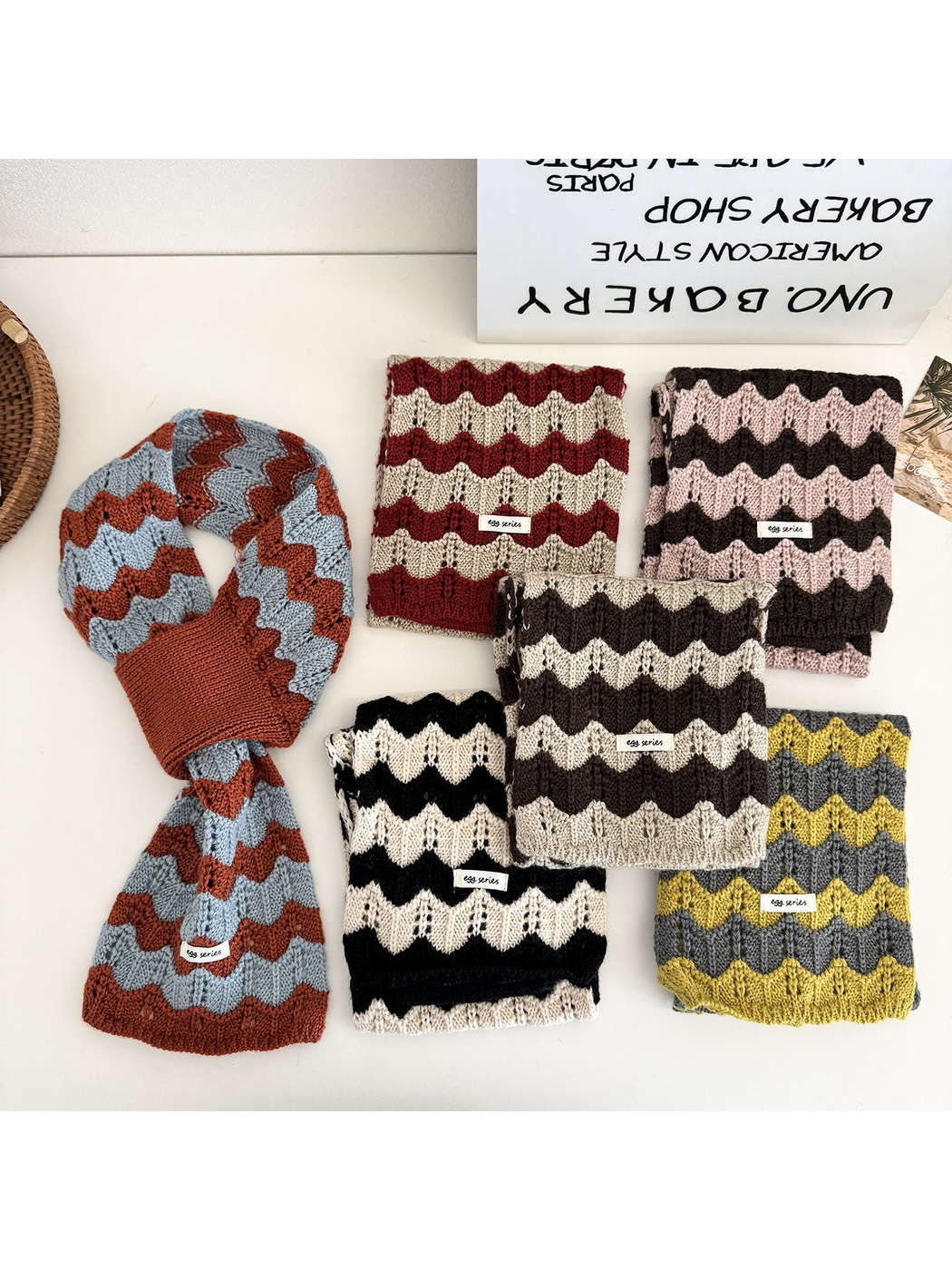 Six color variations of the wavy knit pull-through scarf displayed flat