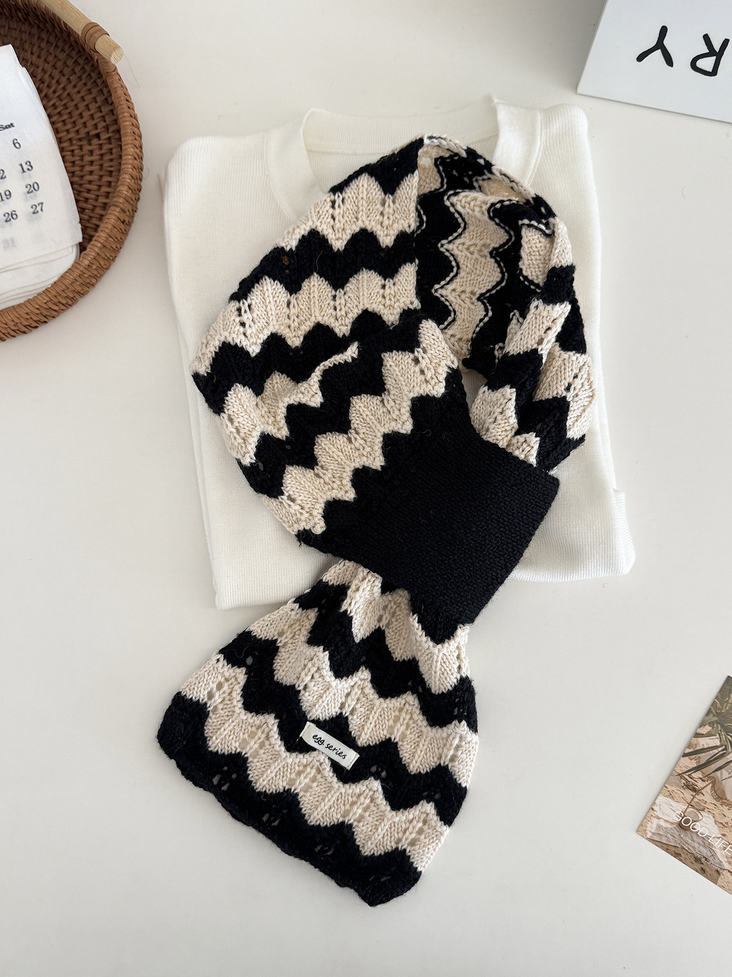 Black and white wavy knit pull-through scarf displayed flat