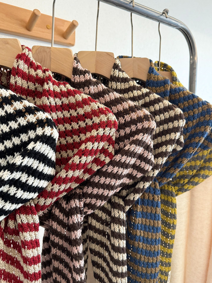 Close-up of striped knit texture across multiple scarf colors