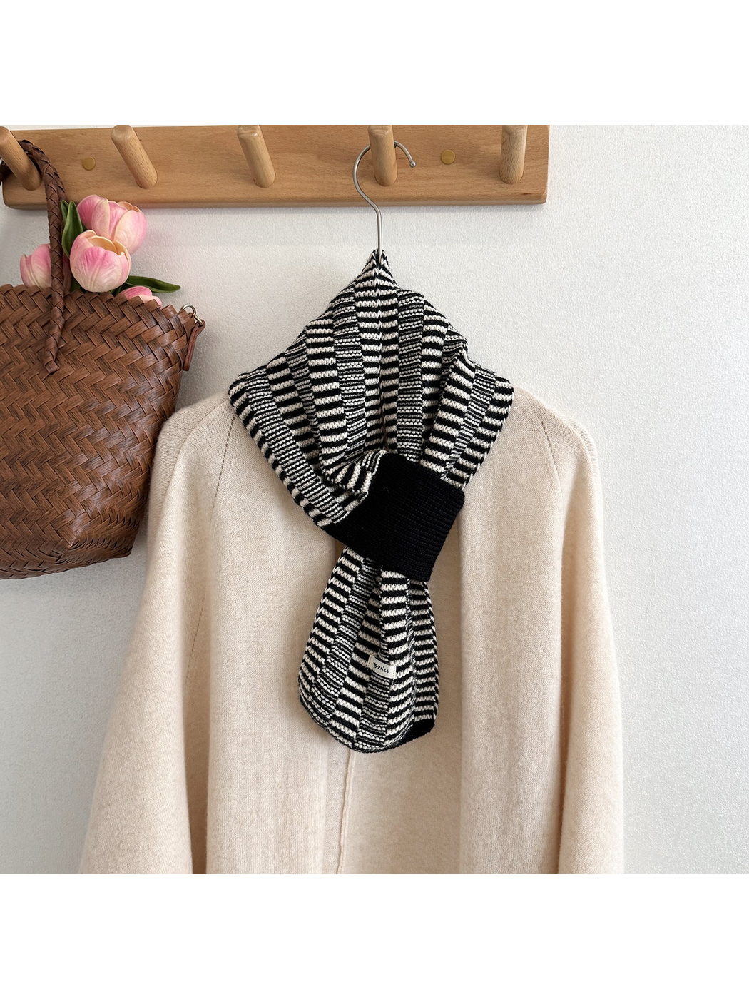 Black / White geometric pull-through scarf styled over a cream sweater