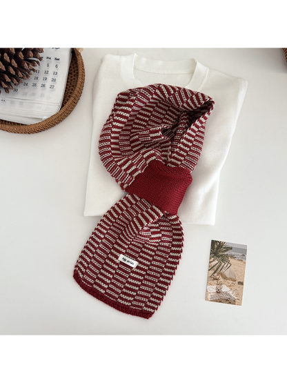 Burgundy geometric pull-through scarf arranged over a folded cream top