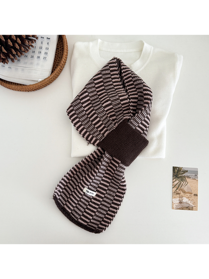 Pink / Brown geometric pull-through scarf arranged over a folded cream top