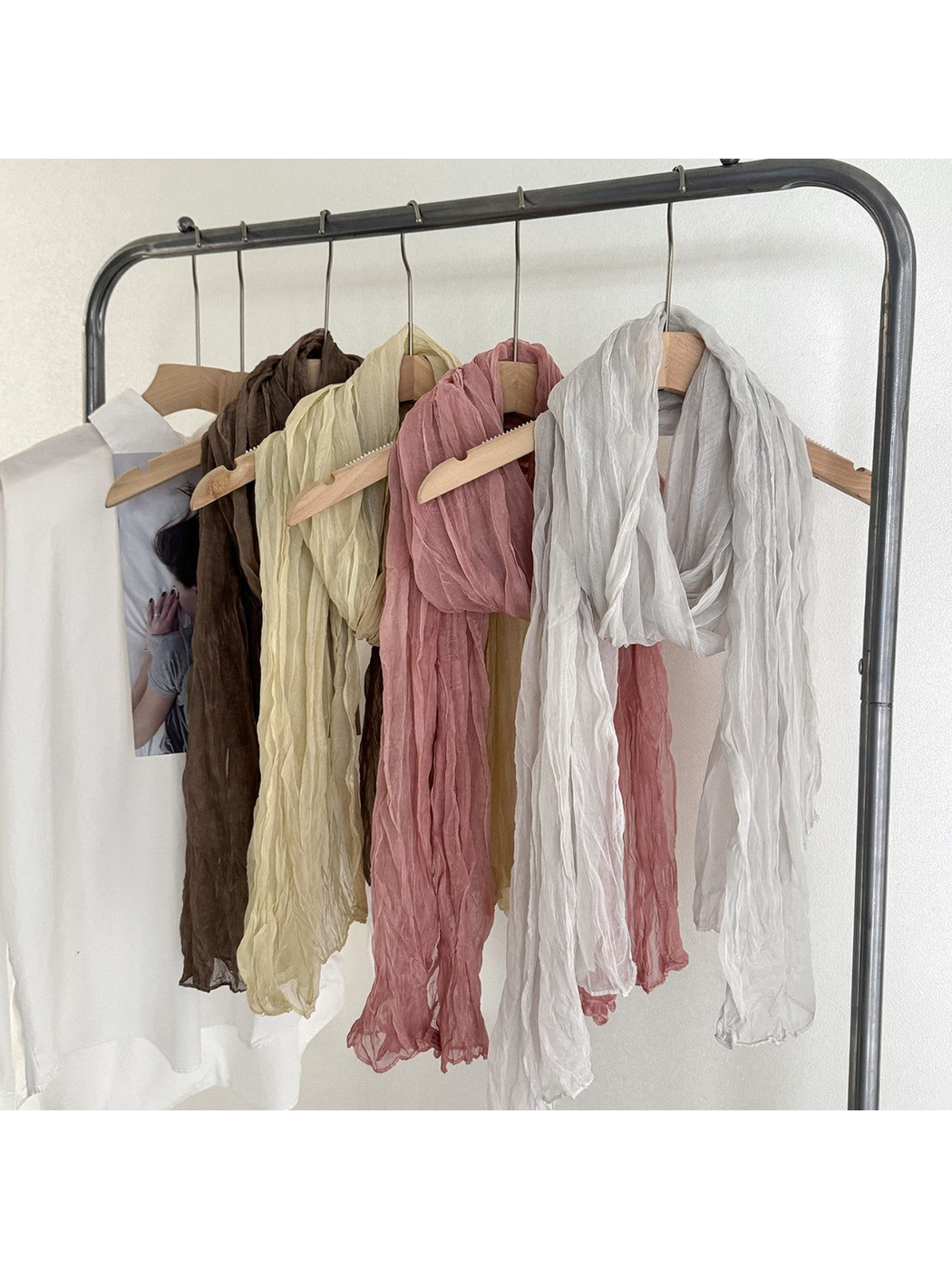 Brown, cream, dusty pink and white crinkled scarves displayed on hangers
